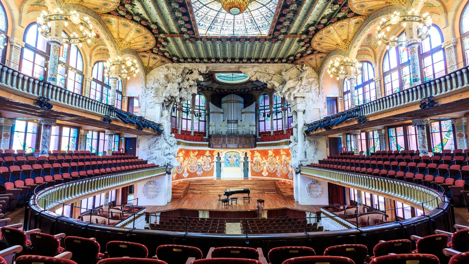 Saal des Konzerthauses mit großer Orgel über der Bühne, viel farbiges Glas und Mosaik