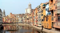 Direkt an einen Fluss angrenzend stehen die bunten, mehrstöckigen Altstadthäuser von Girona