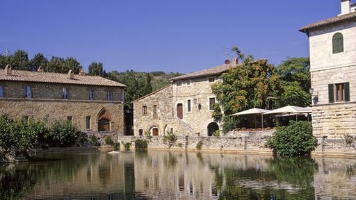 Im Vordergrund das alte Thermalbecken von Bagno Vignoni, umringt von den mittelalterlichen Gebäuden der Therme.