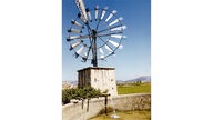 Eine Windmühle steht auf einem Feld auf der Insel Mallorca.
