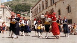 Eine Folklore-Gruppe tanzt auf einem historischen Markt in Dubrovnik. 