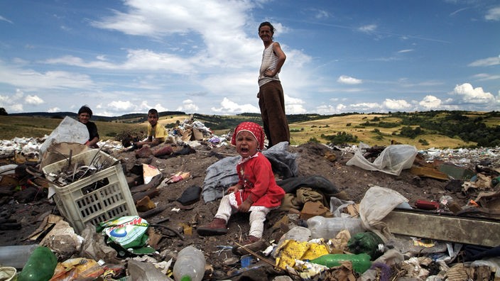 Eine Sinti-Familie sammelt Altmetall auf einer Müllkippe.