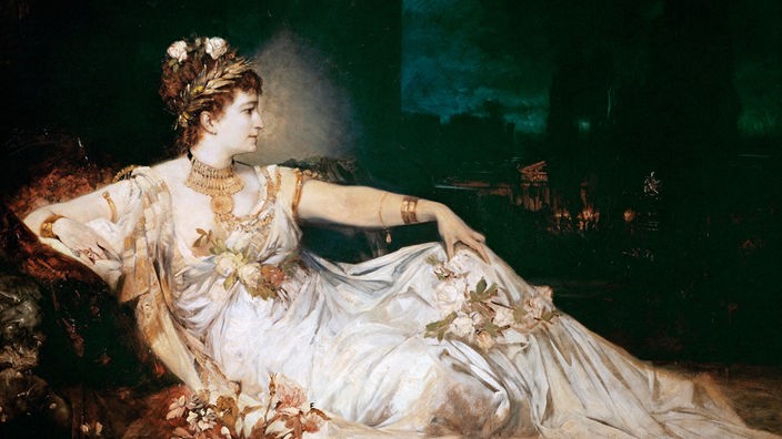 Ein Ölgemälde zeigt die Schauspielerin Charlotte Wolter in Bühnengarderobe in der Rolle der Messalina, liegend und mit Blumen geschmückt.