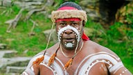 Bemalter Aborigine mit Federschmuck.