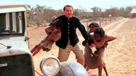 Filmszene: Ein weißer Mann in Uniform entreißt ein Aboriginal-Mädchen seiner Familie.