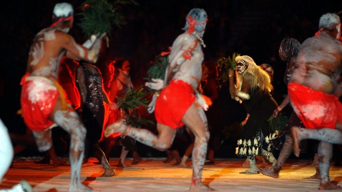 Eine Gruppe bemalter Aborigines bei Ritualtanz.
