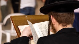 Orthodoxe Juden beten vor der Klagemauer in Jerusalem und studieren dabei Gebetsbücher