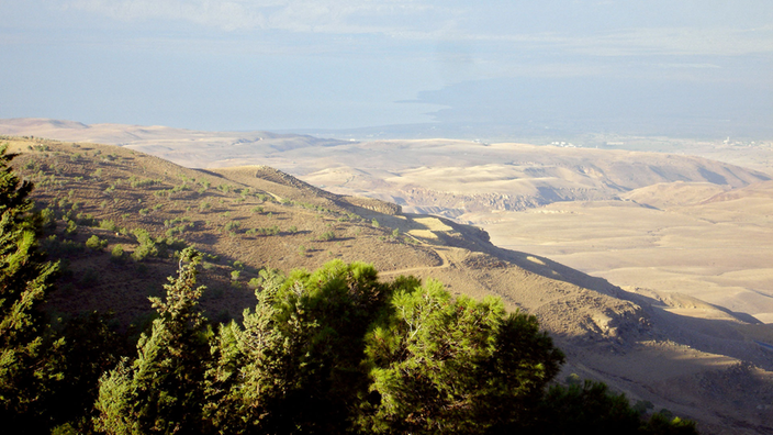 Wüstenlandschaft und Meer von einem Berg aus gesehen.
