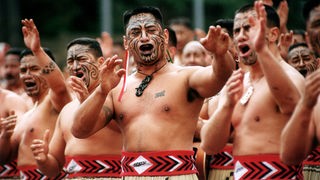 Das Bild zeigt eine Gruppe Männer mit nacktem Oberkörper bei einem traditionellen Tanz.