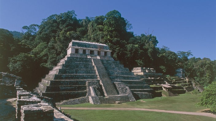 Ein pyramidenförmiger Tempel mit vielen steilen Stufen, auf dessen Spitze ein Haus mit fünf Toren steht.