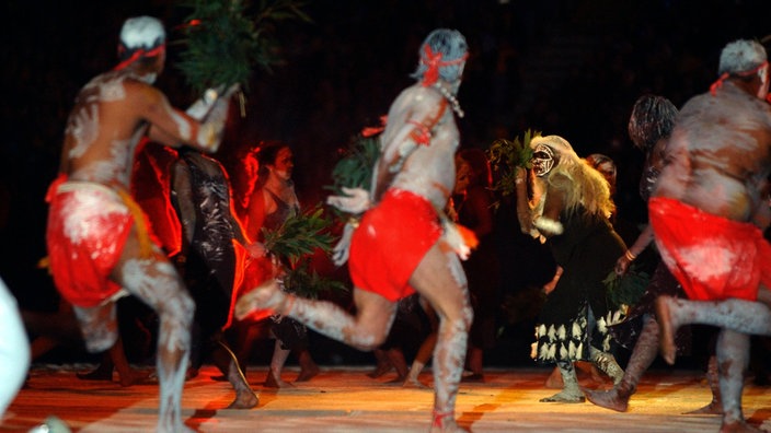 Eine Aborigines-Tanzgruppe bei einer Vorführung auf der Eröffnungsfeier des Rugby World Cups 2003. | Bildquelle: dpa Eine Aborigines-Tanzgruppe bei einer Vorführung auf der Eröffnungsfeier des Rugby World Cups 2003.
