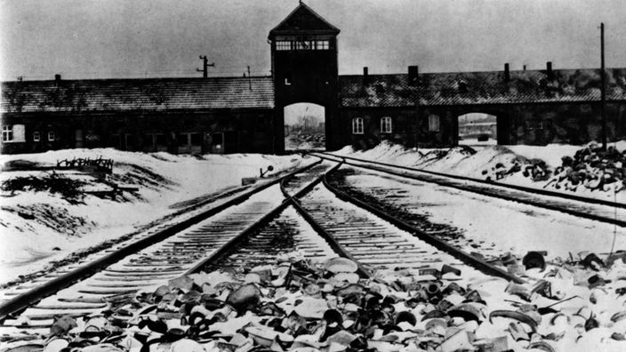 Ehemaliges Konzentrationslager Auschwitz-Birkenau: Blick auf die Schienen der Rampe, an der die Häftlinge ausgeladen wurden, im Hintergrund das Eingangsgebäude