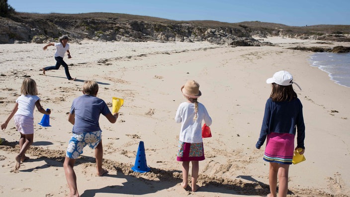 Kinder spielen an einem Strand