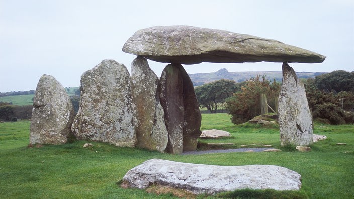 Ein Hünengrab steht auf einer begrünten Anhöhe in Irland.