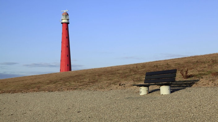 Deich und Leuchtturm in den Niederlanden. | Bildquelle: imago stock&people Deich und Leuchtturm in den Niederlanden.