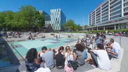 Water Square Benthemplein Rotterdam bei gutem Wetter mit vielen Leuten.