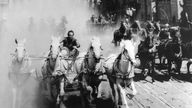 Filmszene: Ben Hur und seine Gegner während des Wagenrennens