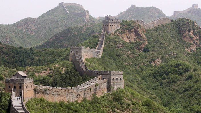 Chinesische Mauer schlängelt sich einen Berg hinauf.