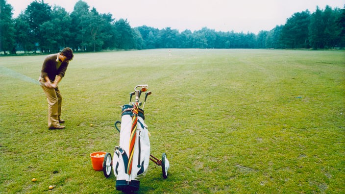 Ein Mann auf einem Golfplatz mit einem Golfschläger in der Hand