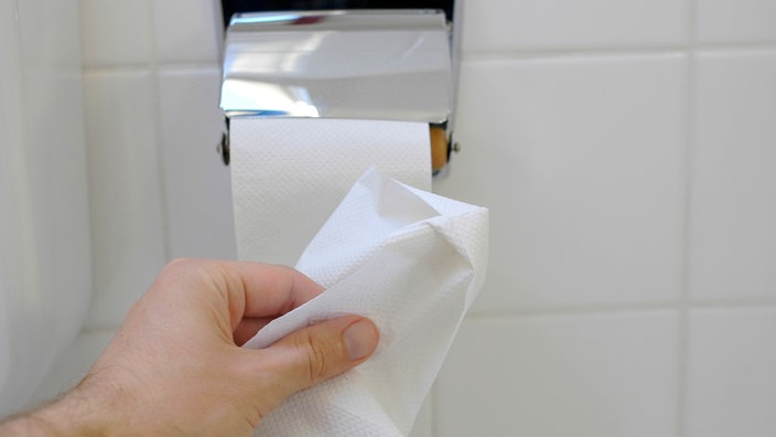 Nahaufnahme einer Toilettenrolle und einer Hand, die Papier | Bildquelle: wdr Nahaufnahme einer Toilettenrolle und einer Hand, die Papier
