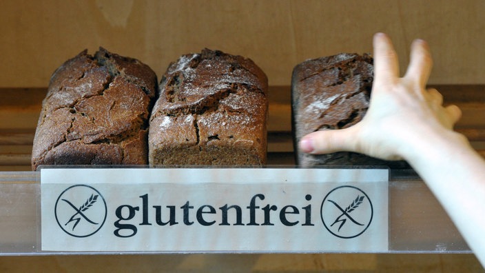 Eine Hand greift nach glutenfreiem Brot | Bildquelle: dpa/Peter Endig Eine Hand greift nach glutenfreiem Brot