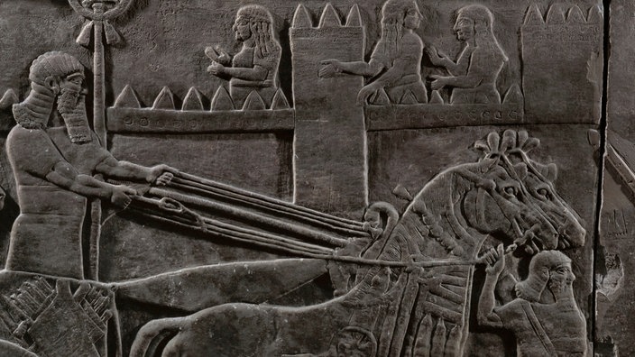 Steinrelief vom Palast in Nimrud: Pferdegespann vor einer Stadtmauer | Bildquelle: picture-alliance / akg-images / Erich Lessing Steinrelief vom Palast in Nimrud: Pferdegespann vor einer Stadtmauer
