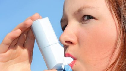 Eine Frau inhaliert ein Asthmaspray