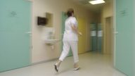 Eine Hebamme rennt über den Flur im Krankenhaus
