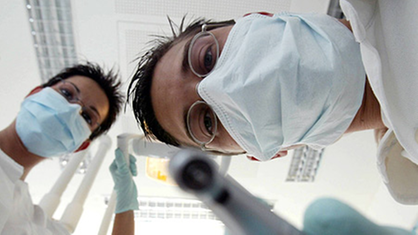 Zahnarzt und Zahnarzthelferin aus der Perspektive des Patienten. | Bildquelle: ddp/Lang Zahnarzt und Zahnarzthelferin aus der Perspektive des Patienten.
