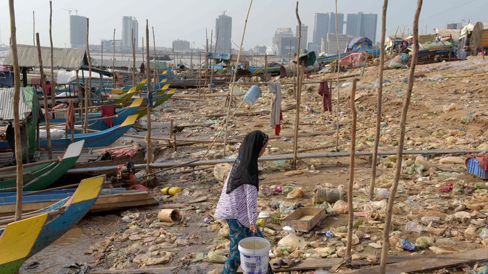 Boote und Müll am Ufer des Mekong, im Hintergrund Hochhäuser | Bildquelle: AFP/Tang Chhin Sothy Boote und Müll am Ufer des Mekong, im Hintergrund Hochhäuser