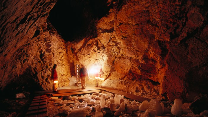 Höhlenwände werden von einem gedämmten, rötlichen Licht angestrahlt