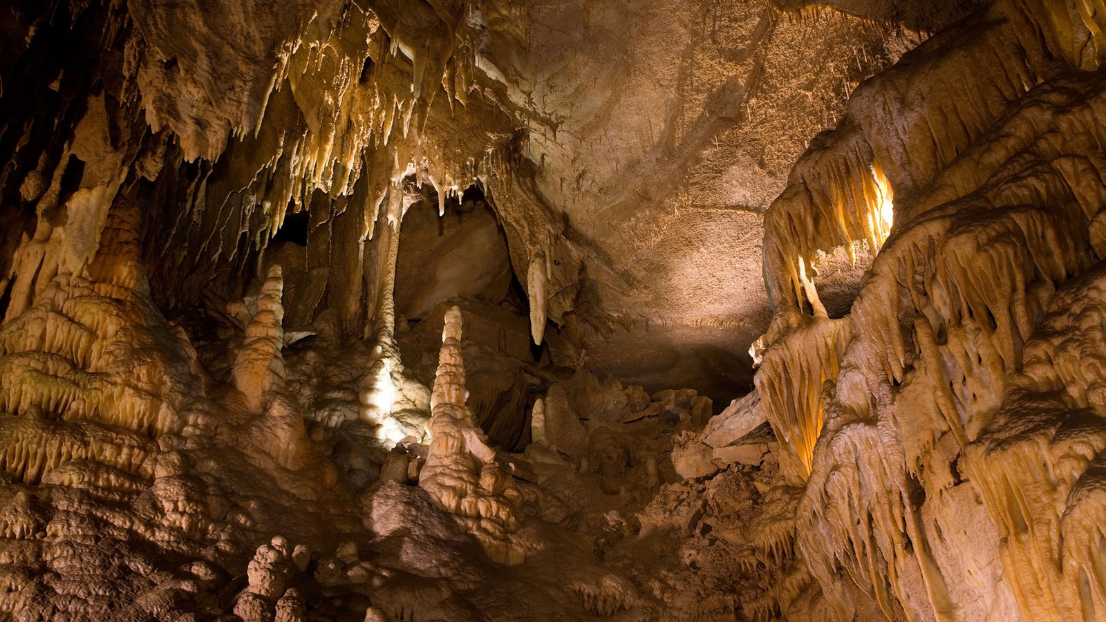 Blick in die Mammut-Höhle, die Wände sind sandfarben und Tropfsteine zu sehen. 