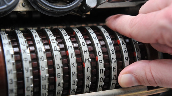 Ein dicker brauner Stab mit verschiedenen Ringen, auf denen Buchstaben zu sehen sind. | Bildquelle: Dpa/Picture Alliance Ein dicker brauner Stab mit verschiedenen Ringen, auf denen Buchstaben zu sehen sind.