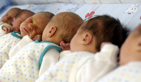 Drei neugeborene Zwillingspaare liegen nebeneinander.