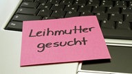 Post-it auf Computertastatur mit der Aufschrift "Leihmutter gesucht"