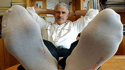 Ein Mann legt die Beine auf den Tisch, um seine Anti-Stink-Socken zu zeigen.