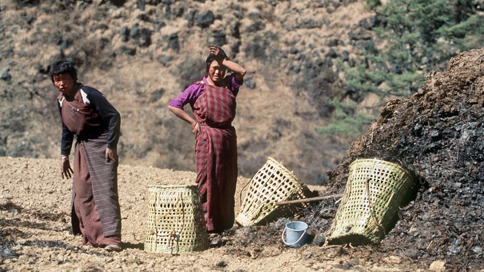 Zwei Frauen arbeiten auf einem Feld in Süd-Bhutan.