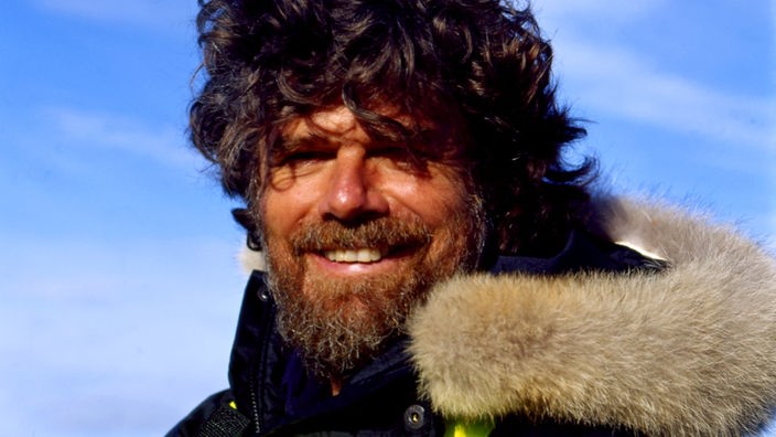 Bergsteiger Reinhold Messner mit dicker Jacke, langen Haaren und dichtem Vollbart.