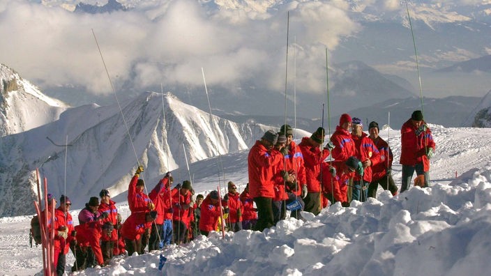 Männer der Bergwacht suchen im Pistenbereich des Schneeferners auf der Zugspitze mit Sonden nach Verschütteten.