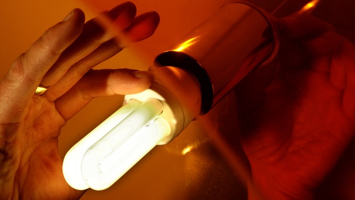 Eine Hand hält eine Energiesparlampe. | Bildquelle: dapd/Michael Kappeler Eine Hand hält eine Energiesparlampe.
