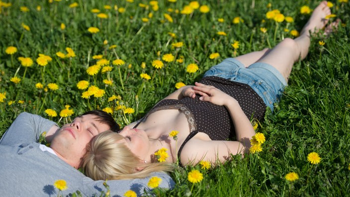 Ein junges Paar in einer Blumenwiese