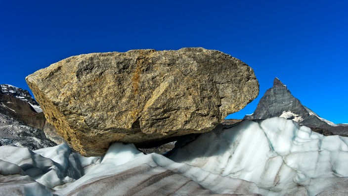 Ein großer Felsbrocken wird vom Gletschereis talwärts transportiert