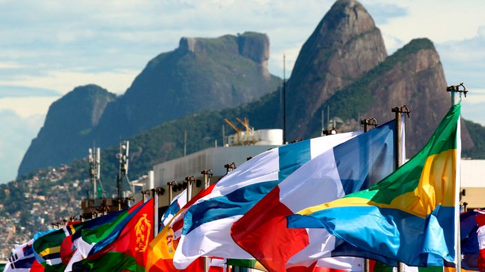 Viele Flaggen wehen an der Copacabana in Rio, im Hintergrund der Zuckerhut
