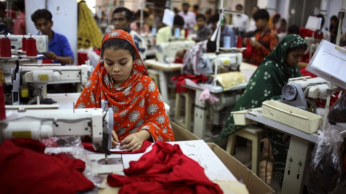 In einer Fabrik in Dhaka in Bangladesch sitzen Menschen an Nähmaschinen. | Bildquelle: WDR / Visum In einer Fabrik in Dhaka in Bangladesch sitzen Menschen an Nähmaschinen.