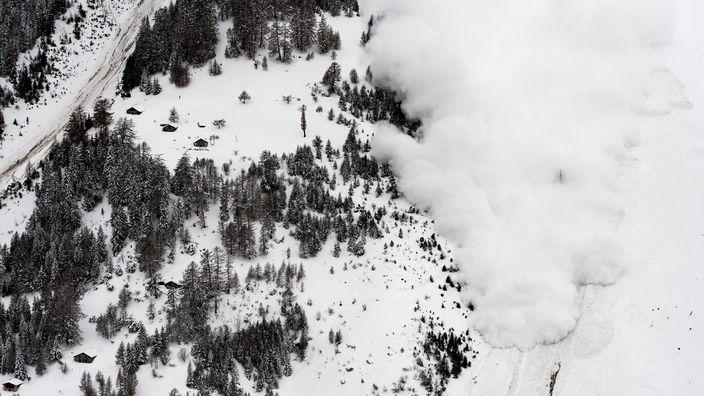 Die Luftaufnahme zeigt, wie Schneemassen einen Berg hinunterrollen