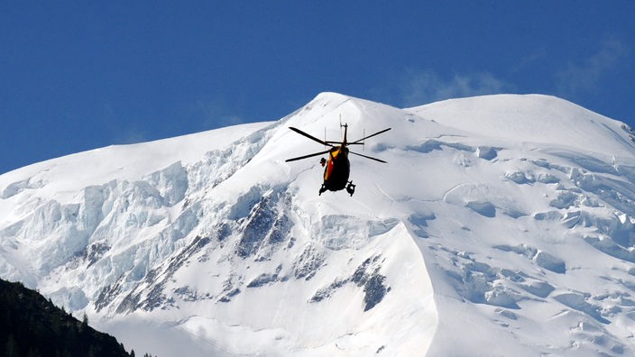 Ein Rettungshubschrauber fliegt in Richtung Berge