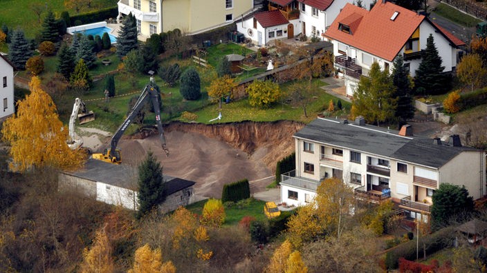 Luftbild von Bagger, der Kies in Grube verteilt