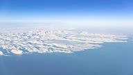 Ein großes Eisschild an der Küste Grönlands ist von oben zu sehen.