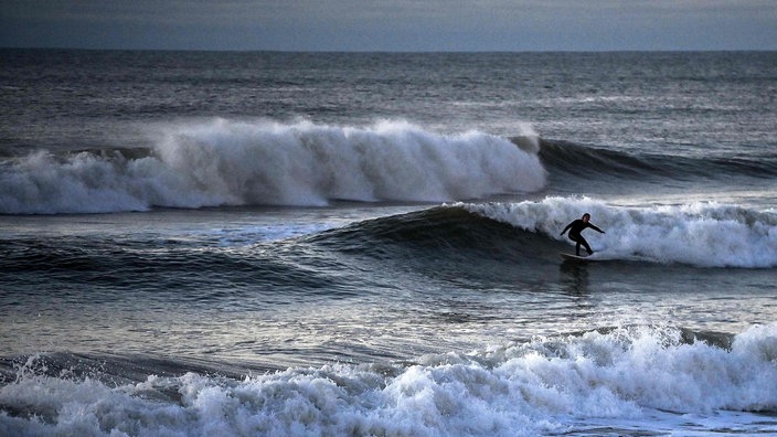 Ein Surfer auf den Wellen der Atlantikküste bei Lacanau, Frankreich | Bildquelle: AFP/CHRISTOPHE ARCHAMBAUL Ein Surfer auf den Wellen der Atlantikküste bei Lacanau, Frankreich
