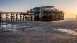 Die Seebrücke von St. Peter-Ording bei Sonnenuntergang | Bildquelle: IMAGO/Frank Röder Die Seebrücke von St. Peter-Ording bei Sonnenuntergang